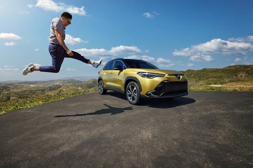 Excited Guy Jumping in Front of Toyota
