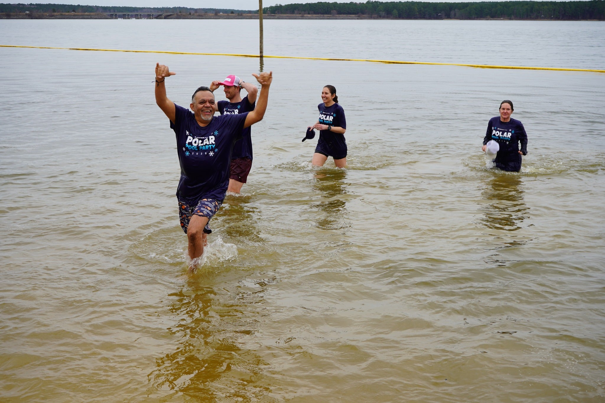 Team members standing by sponsor sign at Polar Plunge