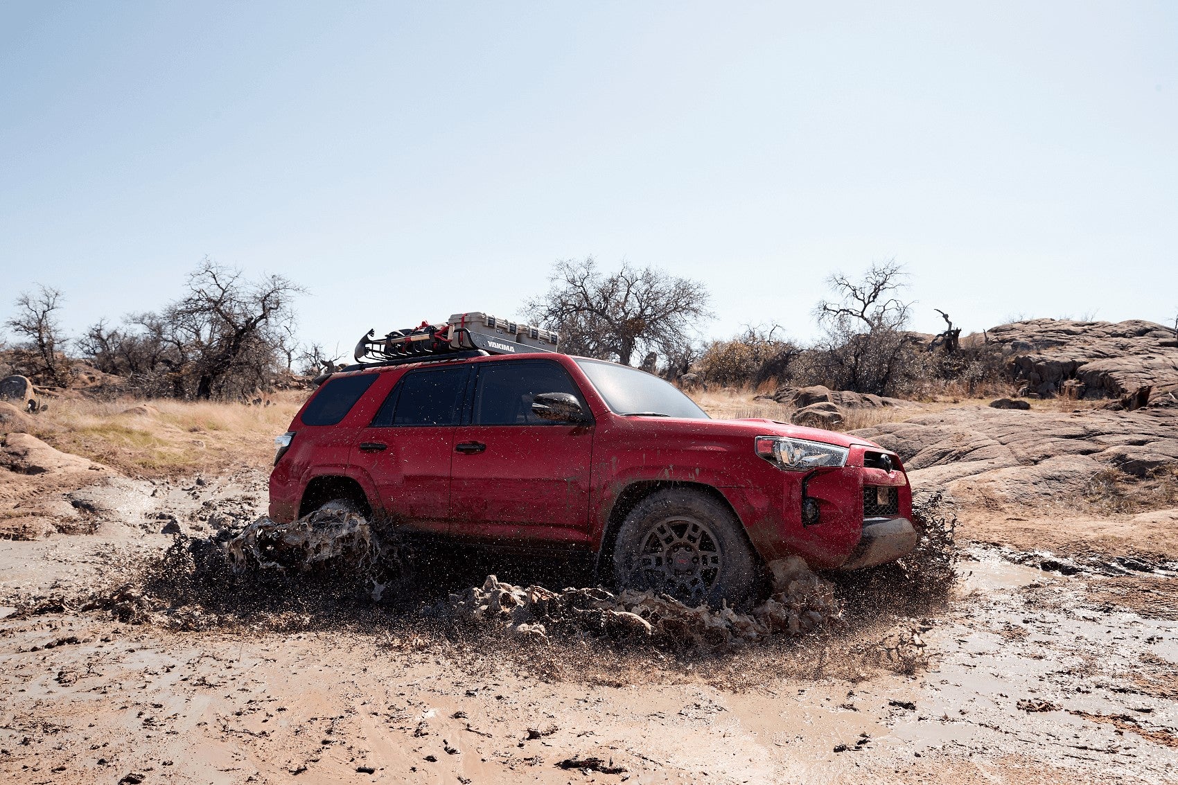 Red Toyota 4Runner driving through mud