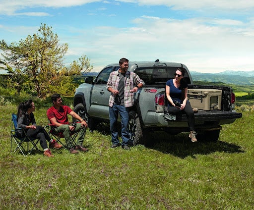 Truck with person in truck bed and people around truck