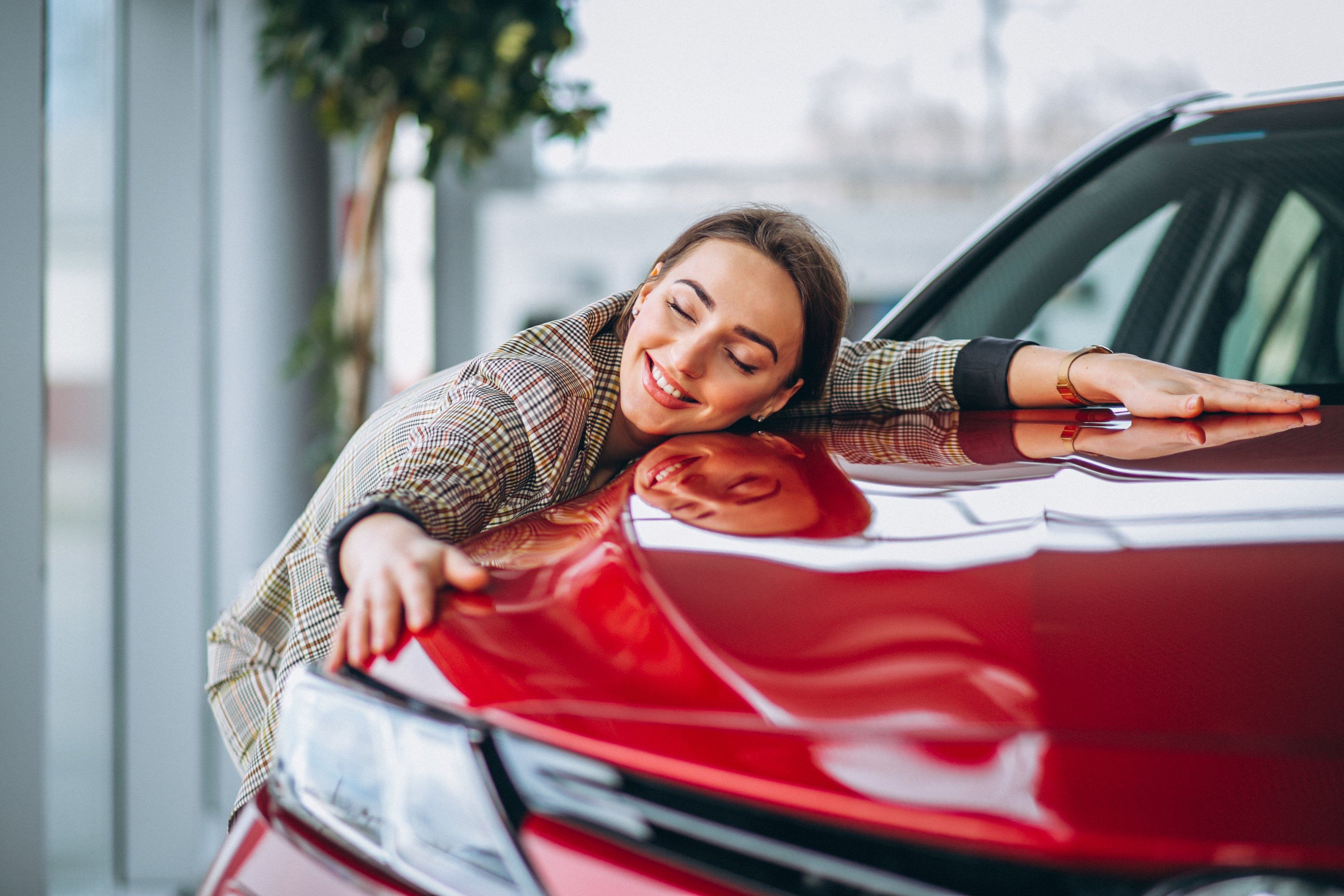 Woman hugging red vehicle 